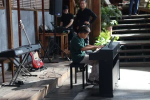 Người biểu diễn ngồi tại piano điện trong không gian Vào Hạ.