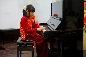 Người biểu diễn piano trong áo dài đỏ tại Sắc Xuân.
