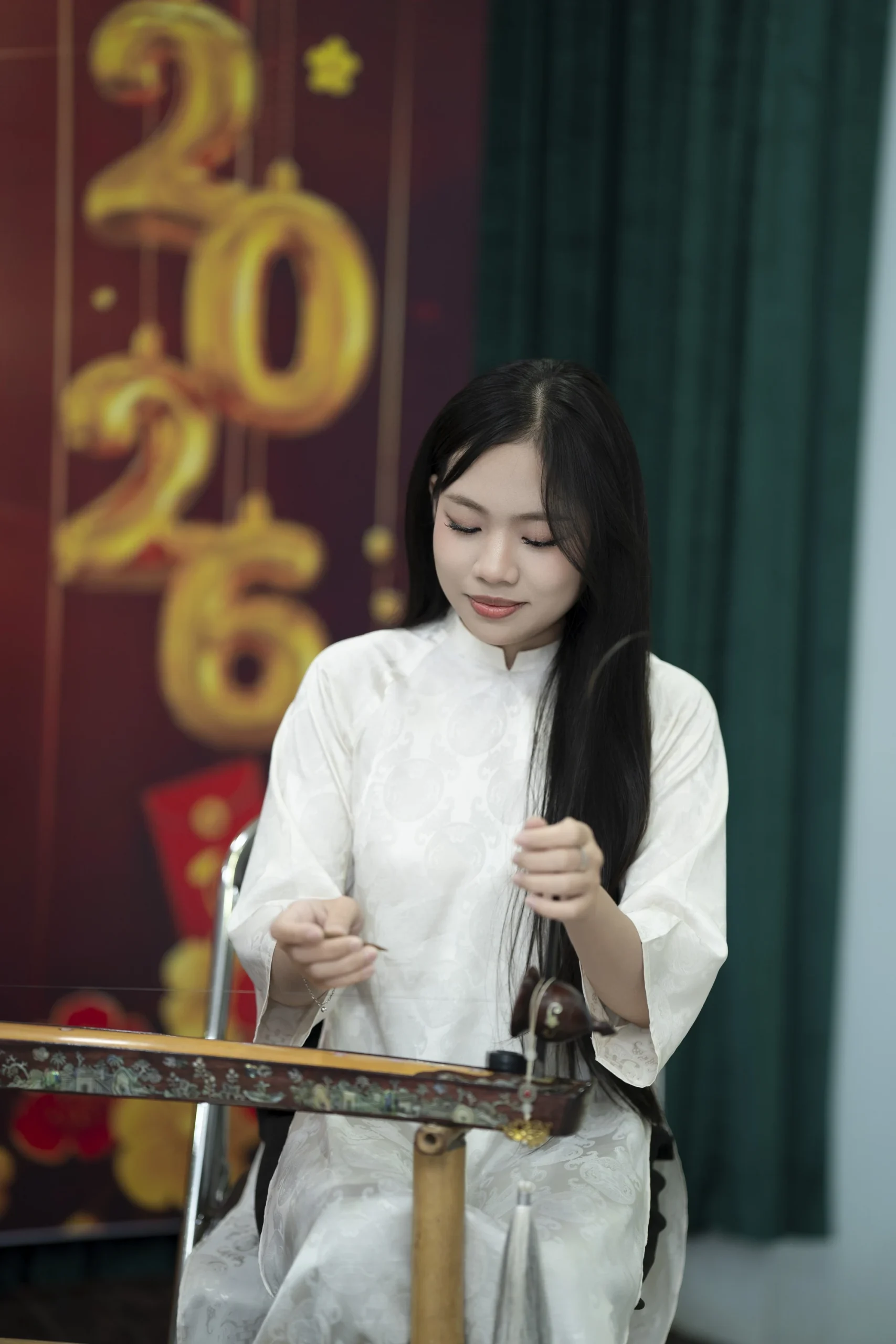 Người biểu diễn đàn bầu trong áo dài trắng tại Giao Mùa.